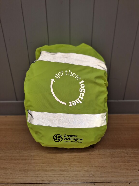 Yellow hi vis backpack cover on display, with reflective stripes and "Get there together" logo